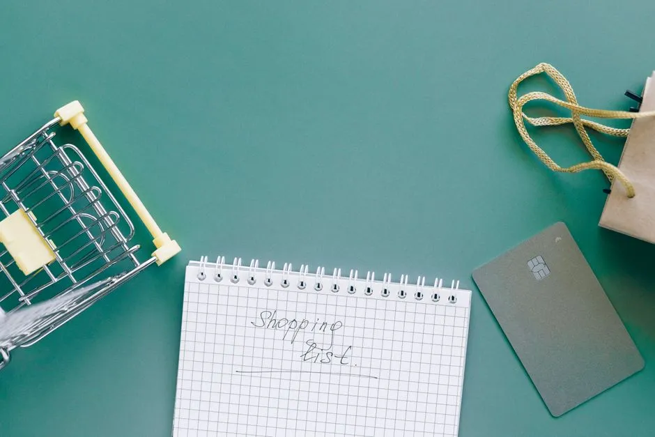 Overhead view of a shopping cart with a shopping list, card, and bag, illustrative stock photo